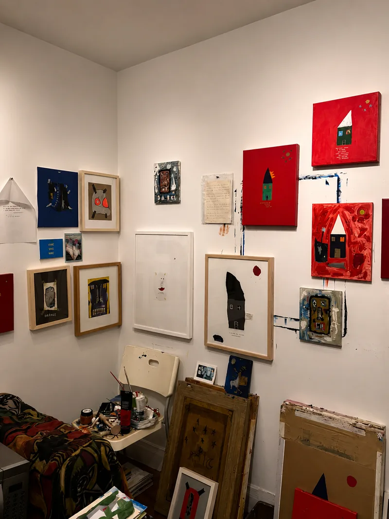 Angle de l’atelier : œuvres encadrées, cadres au sol, toiles en attente