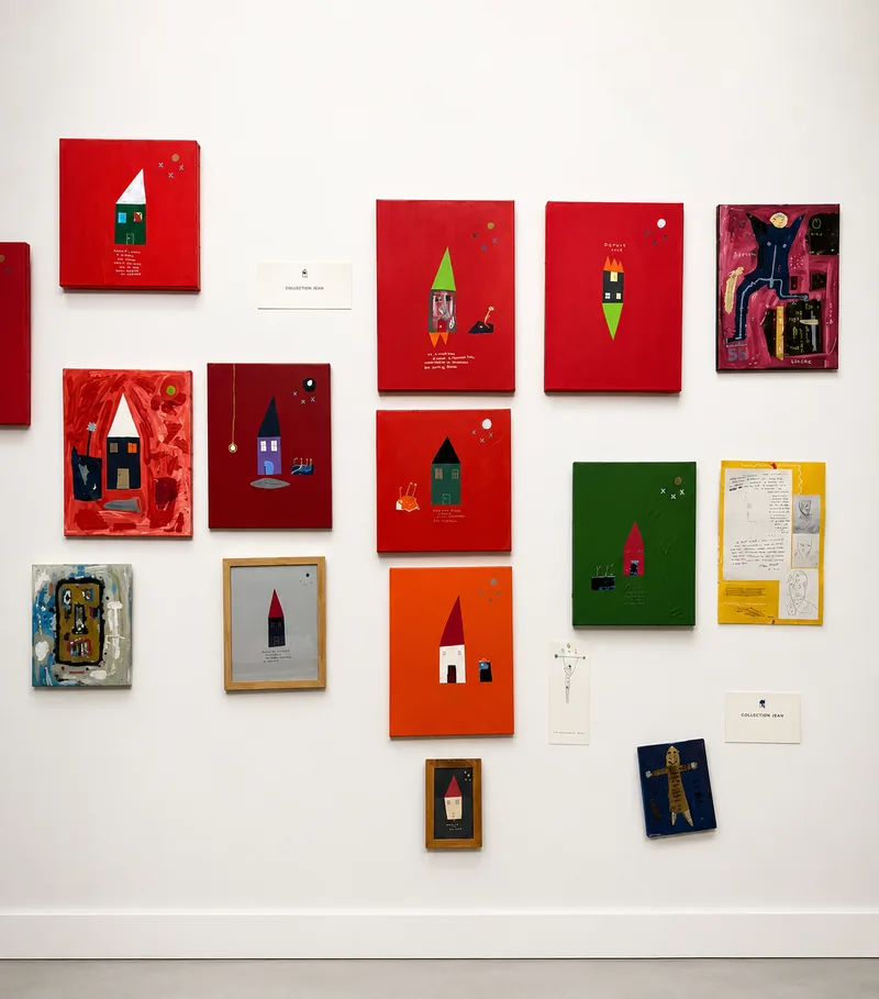 Petits formats rouges, verts et crème disposés en constellation sur un mur blanc